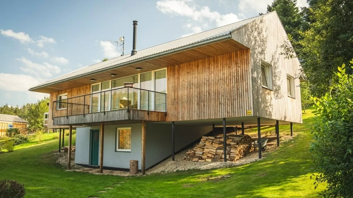 Moderní dům s výrazným přesahem střechy nad patrem.