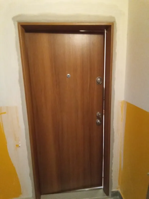 Dřevěná vstupní dveře do bytu s viditelnými spáry po instalaci.