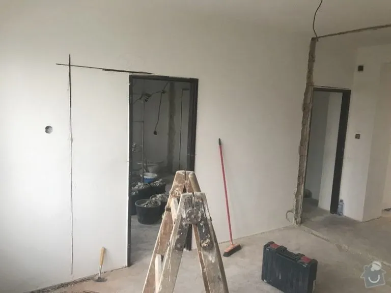 Byt v rekonstrukci s nástroji a nehotovými stěnami.
