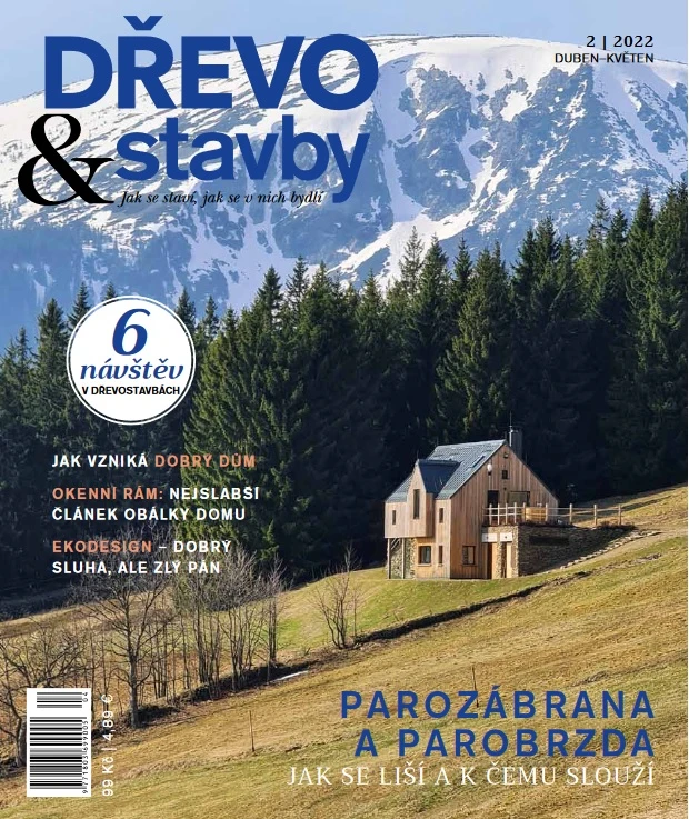 Dřevostavba na kopci s horami v pozadí.