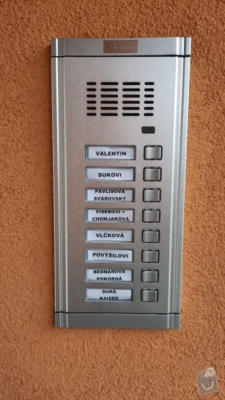 Stříbrný bytový zvonkový panel s tlačítky pro jednotlivé byty.