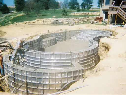 Práce s betonem v tvářnicích při stavbě základů domu.