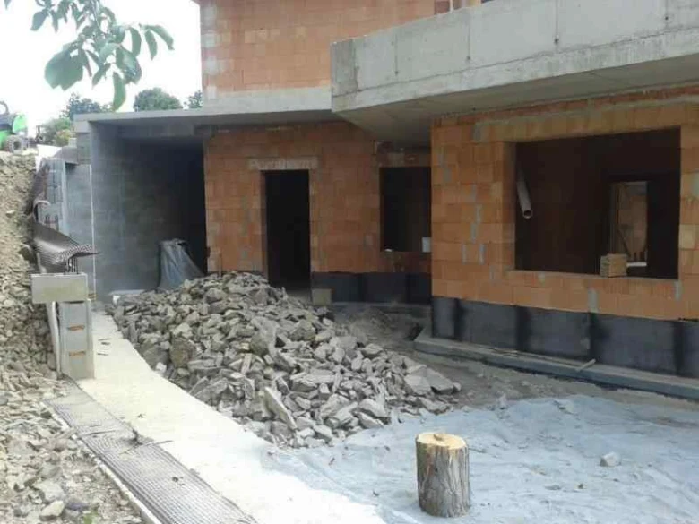 Stavební drenáž v základové části budovy s odvodňovacím kanálem.
