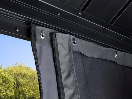 Detail tmavého plátna na zahradní pergole s venkovním posezením.