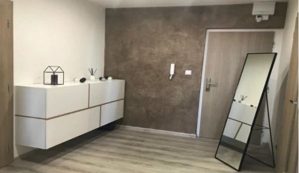 Moderní interiér s betonovou stěrkou na zdi v obývacím pokoji.