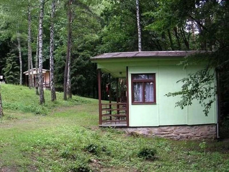 Malý dřevěný domek v lese u Vranovské přehradnice pro ubytování.