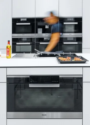 Modern kuchyň s vestavěnými elektrickými troubami a varnou deskou.